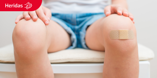 Persona sentada con una herida en la rodilla Persona sentada con una herida en la rodilla